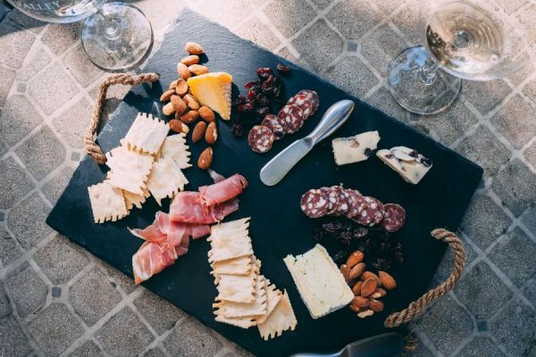 An example of a charcuterie board featuring cheese, salami, crackers, and nuts.